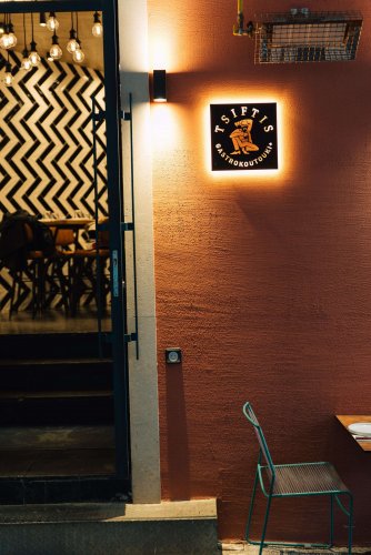 the entrance of a restaurant with sign that reads "tsiftis"
